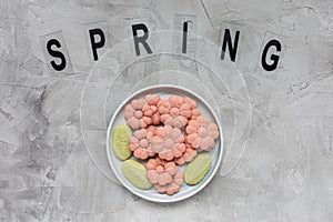 SPRING word and flower cookies on a plate on a gray background . Spring holidays cooking concept