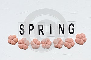 SPRING word and flower cookies on a white background. Spring cooking concept.