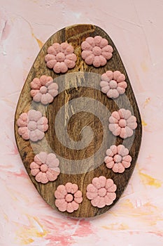 SPRING word and flower cookies on a wooden board on a pink background . Spring holidays cooking concept