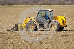 Spring work at farm. Farmer in tractor preparing the field for sowing. Farmer land and traktor