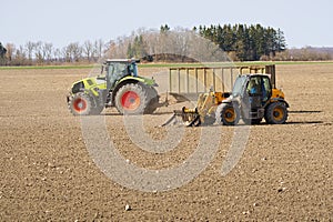 Spring work at farm. Farmer in tractor preparing the field for sowing. Farmer land and traktor