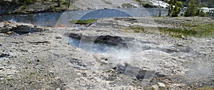 Spring in Yellowstone: Spiteful Geyser & Fan Geyser of the Morning Glory Group on the Bank of Firehole River in Upper Geyser Basin