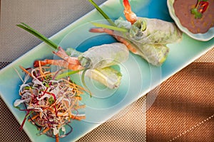 Springroll with vegetables and prawn served with salad and sauce. Asian cuisine.