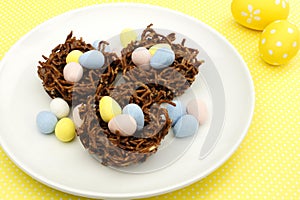 Springtime chocolate nests on yellow background