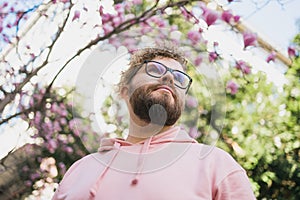 Springtime concept. Bearded man on background bloom of magnolia. Spring beauty season. Botany and nature. Happy spring