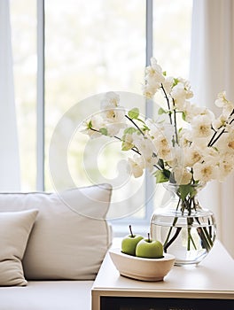 Springtime home decor in white color, spring interior decorations with early flowers, cozy sofa and big windows