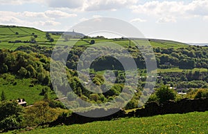 Springtime pennine countryside in calderdale west yorkshire with typical hillside fields, woodland, and houses