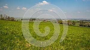 Springtime rural scenery with meadows, fields, forest and dispersed settlement photo