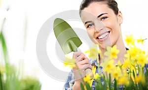 Springtime, smiling woman in garden takes care of flowers