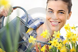 Springtime, smiling woman in garden with watering can, watering