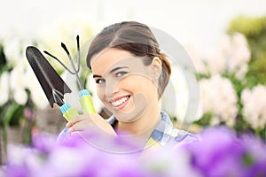 Springtime woman smiling in garden with tools in hands