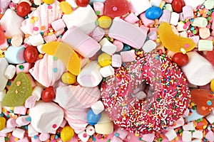 Sprinkle donut on confectionery and sweeties background