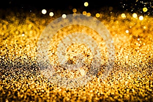 Sprinkle glitter gold dust on a black background