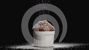 Sprinkle muffin cake with powdered sugar on black background with copyspace