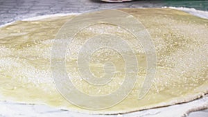 Sprinkle with sugar-sand rolled out the pastry for the preparation of bread rolls.