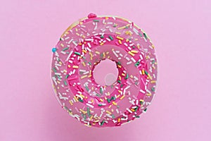 Sprinkled Pink Donut. Glazed sprinkled donut on pink background. Top view, copy space