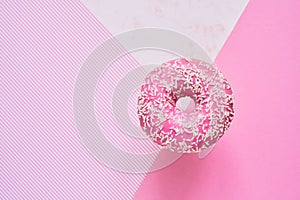 Sprinkled Pink Donut. Glazed sprinkled donut on colorful pink background. Top view, copy space