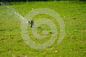 Sprinkler grass working system, working on the field in the garden