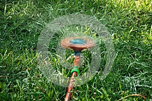 Sprinkler head in blurred motion. Sprinkler splashing water all around