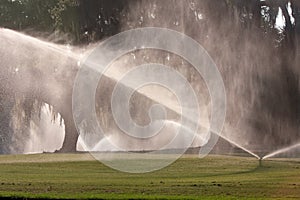 Sprinklers Pour Water Onto Golf Course Fairway