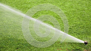 Sprinklers spraying water on the grass in football field