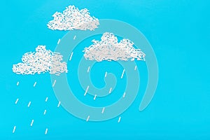 Sprinkles on blue background in form of clouds and rain, concept of children creativity
