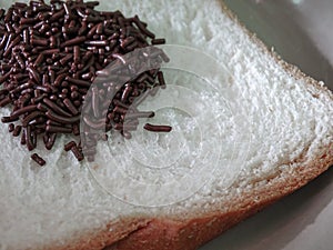 Sprinkling of meses on white bread photo