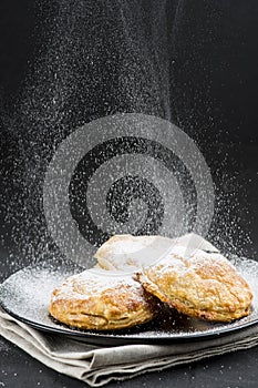 Sprinkling powdered sugar on cakes