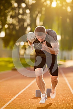 Sprinter leaving starting blocks on the running track. Explosive start.