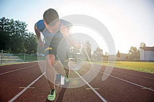 Sprinter leaving starting blocks on the running track. Explosive start.