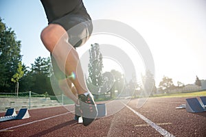 Sprinter leaving starting blocks on the running track. Explosive start.