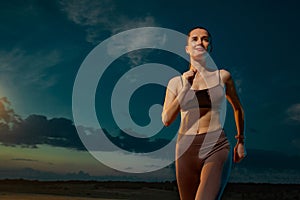 Sprinter run. Strong athletic woman running on black background wearing in the sportswear. Fitness and sport motivation