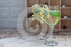 Spritzer cocktail with white wine, mint and ice, decorated with spiral lemon zest, copy space
