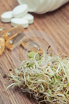 Sprouts as source vitamins and tablets supplements. Choice between healthy eating and pills. Alternative medicine