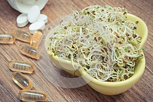 Sprouts as source vitamins and tablets supplements. Choice between healthy eating and pills. Alternative medicine