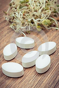 Sprouts as source vitamins and tablets supplements. Choice between healthy eating and pills. Alternative medicine