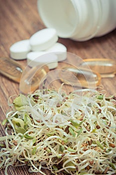 Sprouts as source vitamins and tablets supplements. Choice between healthy eating and pills. Alternative medicine