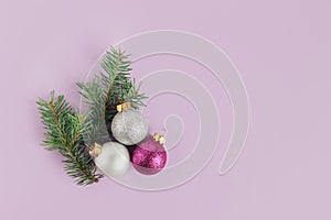 Spruce branches and christmas ornaments on a violet background. Christmas background