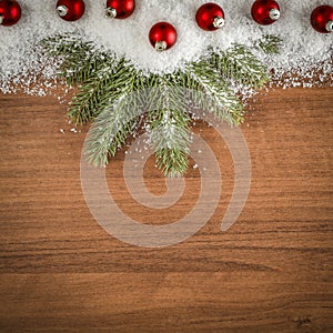 Spruce twigs and baubles on a wooden table flat background. Christmas decorations on wooden board top seen from above.