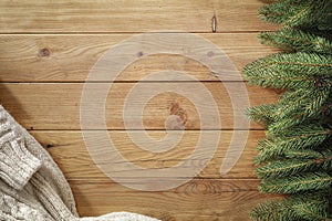 Spruce twigs and blanket on a wooden table flat background. Christmas decorations on wooden board top seen from above.