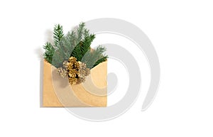 Spruce twigs and golden cones in a craft envelope isolated on a white background. Christmas greeting card. New Year letter. Copy