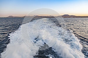 Spume of ferry ship with lanzarote skyline in background