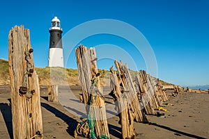 Spurn Point lighthouse and old wooden beach sea defences photo