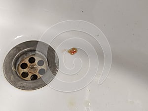 Sputum or saliva with blood in the sink photo