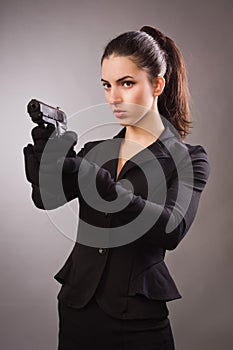 Spy girl in a black shoots a gun