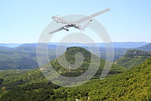 Spy unmanned aerial vehicle & x28;UAV& x29; flies over mountain landscape, rocks and valley in the summer