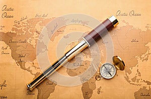 Spyglass and compass on vintage world map. Travel planning concept