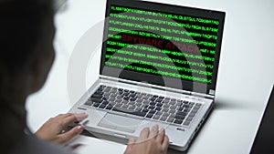 Spyware attack on laptop computer, woman working in office, cybercrime, close up