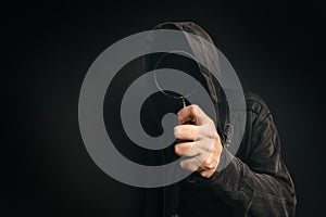 Spyware computer software, hooded spooky person with magnifying