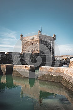 Sqala du Port, a defensive tower at the fishing port of Essaouira, Morocco near Marrakech. Blue sky with clouds and